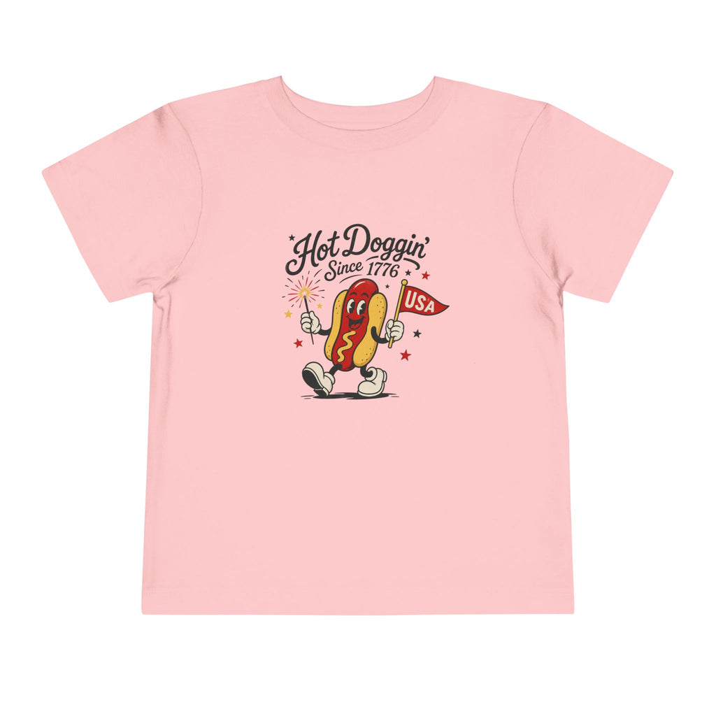 Hot Doggin Since 1776 Tee, Patriotic USA Hot Dog Shirt, Funny Summer Cartoon Graphic Top, Fourth of July Celebration Outfit Toddler Short Sleeve Tee