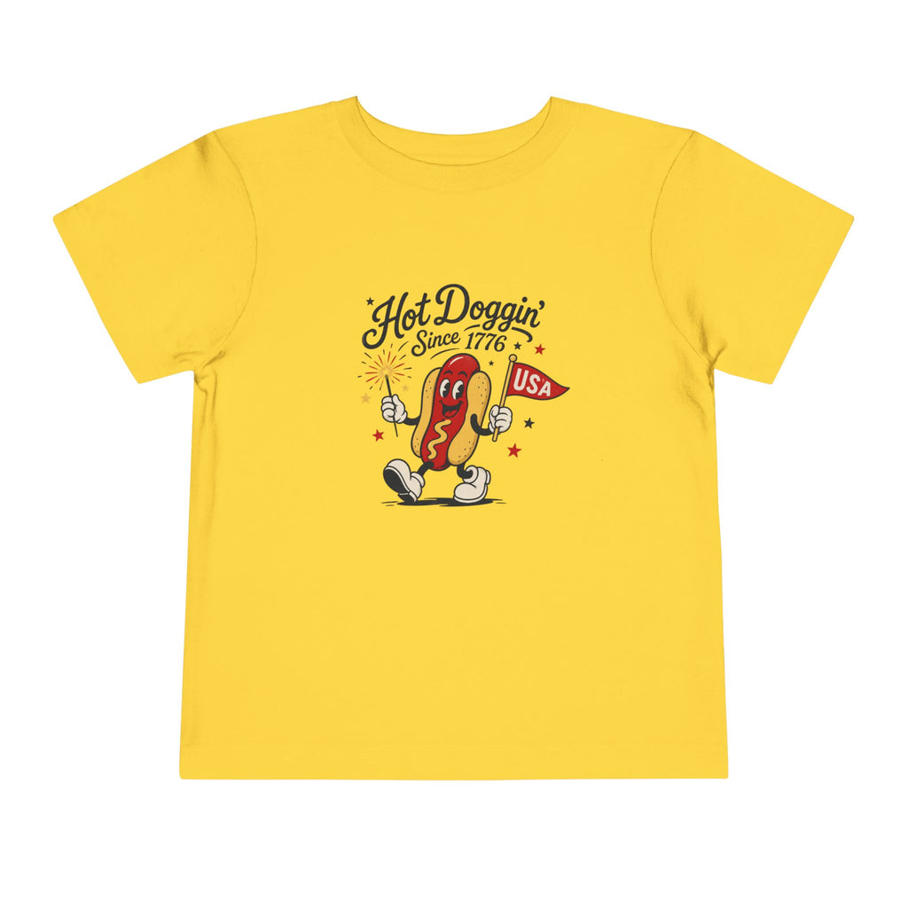 Hot Doggin Since 1776 Tee, Patriotic USA Hot Dog Shirt, Funny Summer Cartoon Graphic Top, Fourth of July Celebration Outfit Toddler Short Sleeve Tee