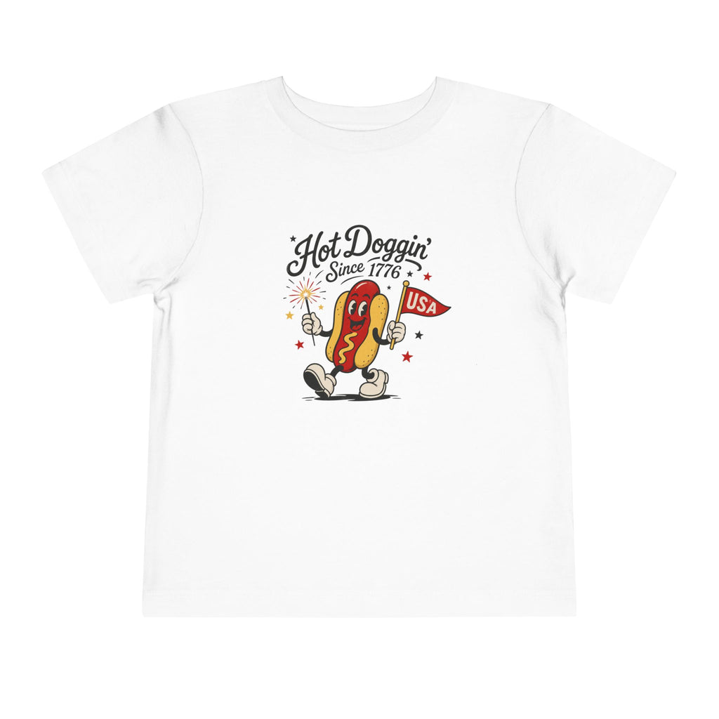 Hot Doggin Since 1776 Tee, Patriotic USA Hot Dog Shirt, Funny Summer Cartoon Graphic Top, Fourth of July Celebration Outfit Toddler Short Sleeve Tee